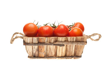 fresh tomatoes on a vine in a wooden basket