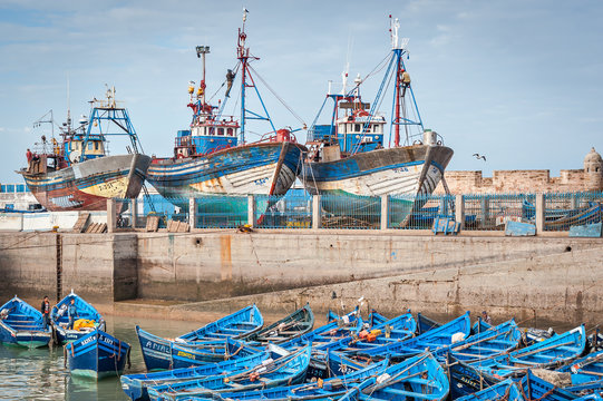 Blue fishing boats and ships in harbor