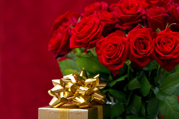 red roses and golden gift with ribbon