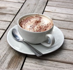 Cup of Cappuccino on wooden slat table