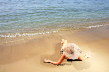 Fototapeta na wymiar Girl on a tropical beach with hat