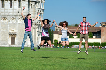 Obraz na płótnie Canvas Group of Friends Jumping with Pisa Leaning Tower on Background