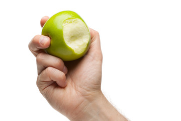 Hand holding green apple with bite missing