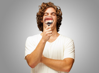 Man Examining His Teeth With Magnifier