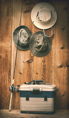 Hats hanging on wall with fishing equipment - 43790706