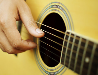 Close up of guitarist hand playing acoustic guitar