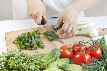 Cook in the kitchen at work preparing vegetable salad