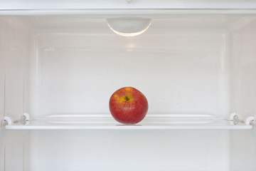 Open empty white refrigerator with an apple diet concept