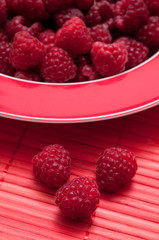 Rote Himbeeren auf rotem Untergrund