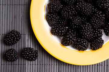 Schwarze Himbeeren auf gelben Teller
