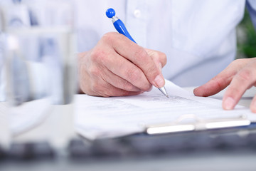 Man’s  hand with pen signing document