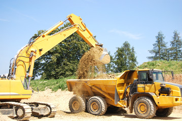 a digger loading a truck with earth
