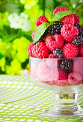 Sweet fresh fruits in glass goblet with mint leaf