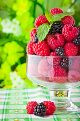Sweet fresh fruits in glass goblet with mint leaf