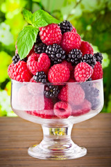 Sweet fresh fruits in glass goblet with mint leaf