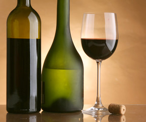 A glass of wine and a bottle