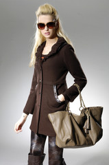 portrait of fashion girl in sunglasses with bag posing