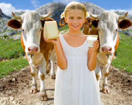 Fresh dairy products - lovely girl and cows in Alps