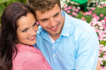 Obraz premium Happy couple hugging in blooming garden