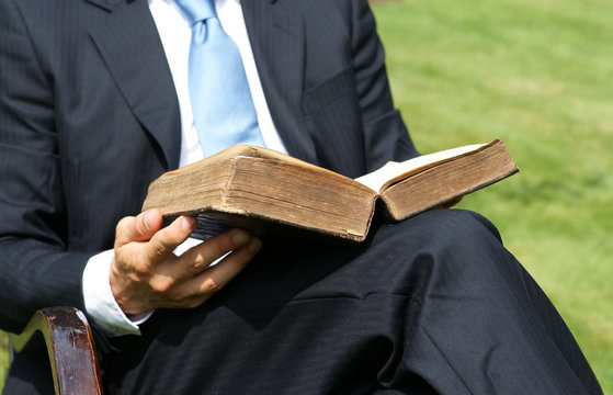Gesch&auml;ftsmann liesst altes Buch und entspannt im Garten 