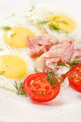 fried eggs with bacon and vegetables