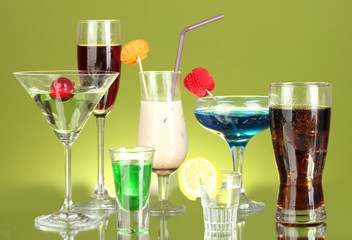a variety of alcoholic drinks on green background