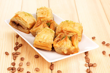 Sweet baklava on plate on wooden background