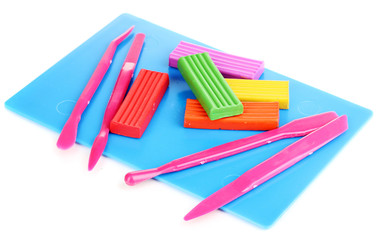 Children bright plasticine on desk with stacks isolated on
