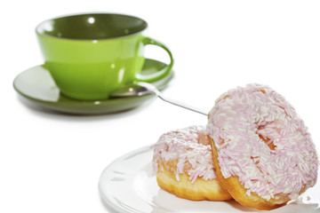 Iced and sprinkled doughnuts on plate and coffee cup