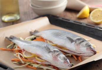 Raw sea bass on a baking sheet