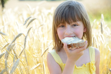 Mädchen mit Butterbrot im Roggenfeld