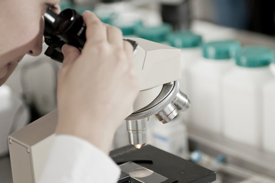 Doctora mirando en un microscopio