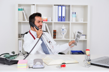 Fototapeta premium Arzt telefoniert und betrachtet ein CT