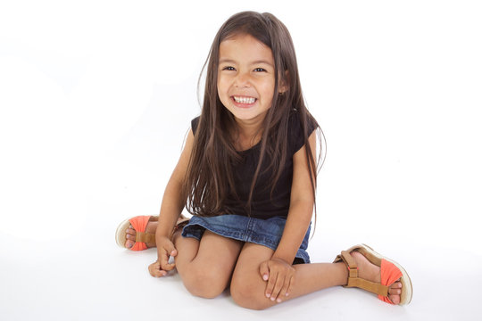enfant assise souriante sur fond blanc