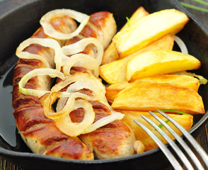 Bratwurst mit Kartoffeln in Pfanne