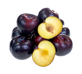Group of ripe plums with one cut in half