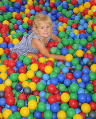 Fototapeta na wymiar Happy girl playing in balls.