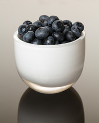 White glass bowl full of blueberries