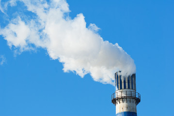 industrial smoke from chimney on blue sky