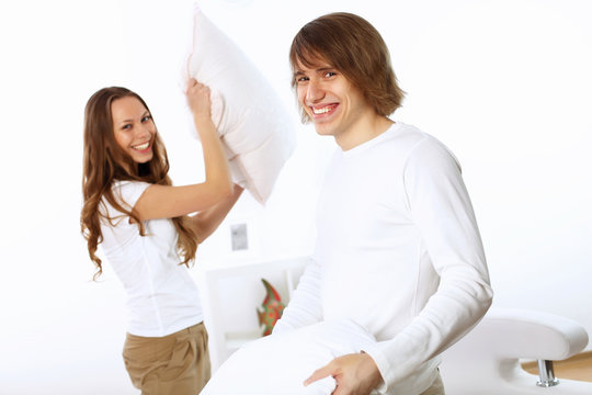 Young couple fighting with pillows