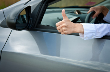 Driver's hand showing thumbs up gesture