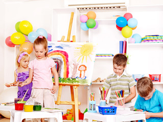 Child painting at easel.