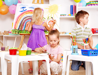 Child painting at easel.