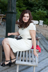 Fototapeta na wymiar Attractive young woman sitting in garden restaurant summer