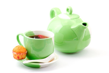 Tea being poured into tea cup isolated on a white background