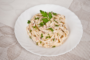 Spaghetti . Fettuccine carbonara in a white bowl, garnished with
