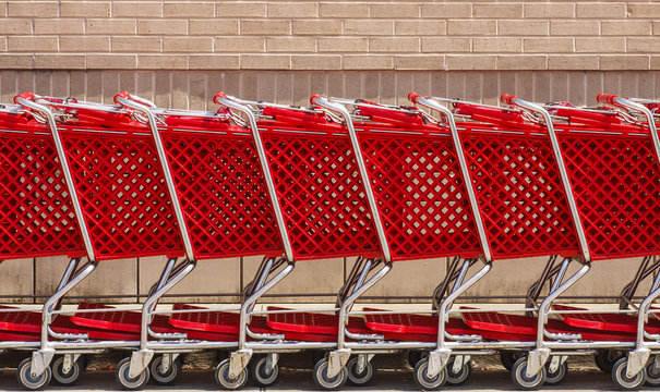 Line of Red Shopping Carts by Brick Wall