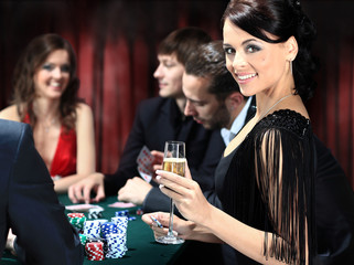 Poker players sitting around a table at a casino