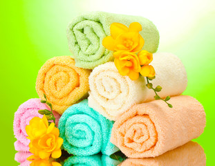 Obraz na płótnie Canvas colorful towels and flowers on green yellow background