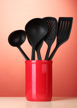 Black Kitchen Utensils In Cup On Red Bakground